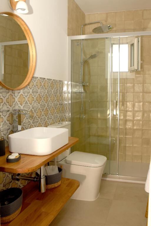 Bathroom with walk-in shower and wooden washbasin unit at Casa Arbonaida